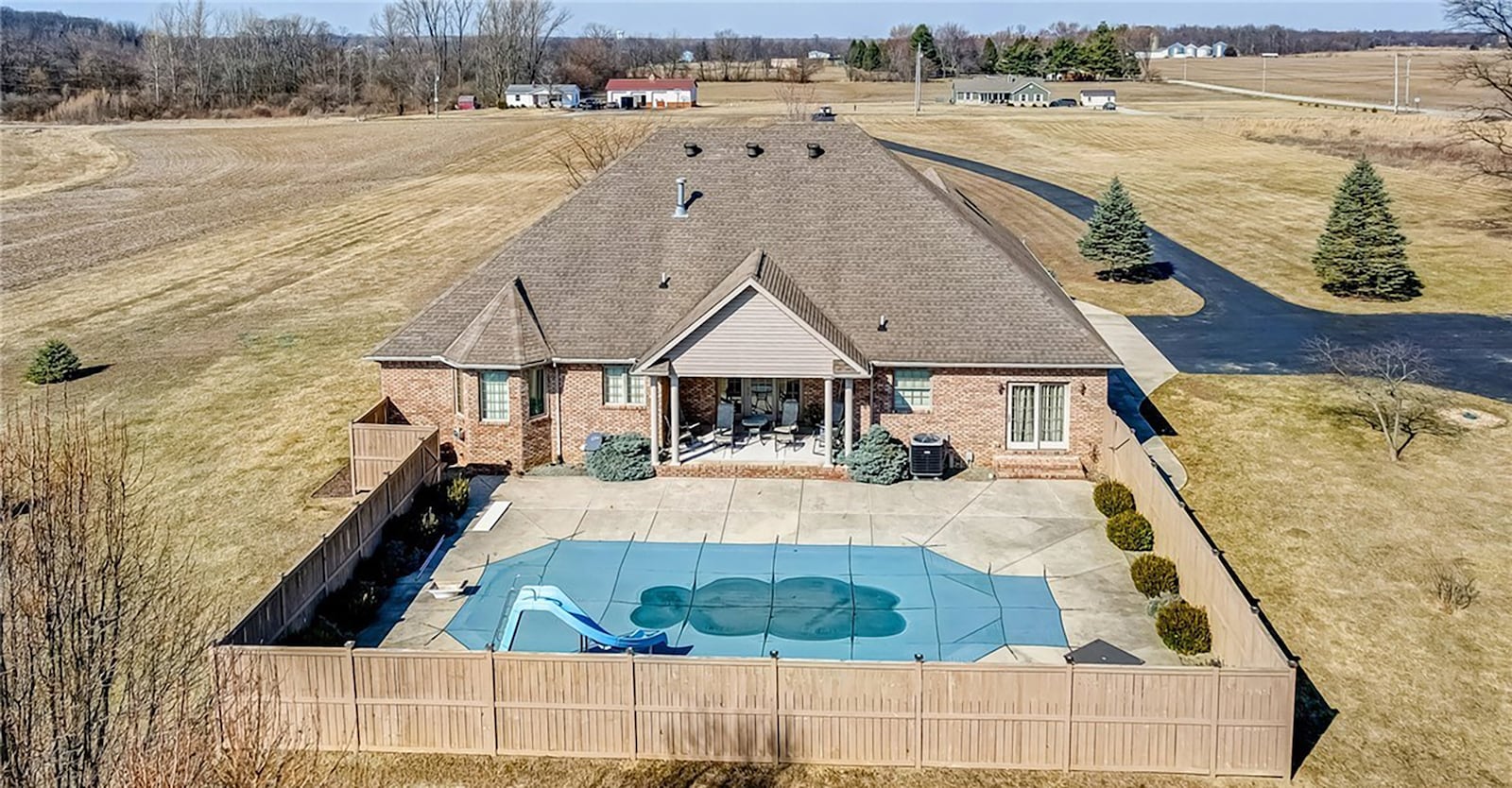 The pool area has a concrete deck and a covered portion off the great room. There is also a wood privacy fence.
